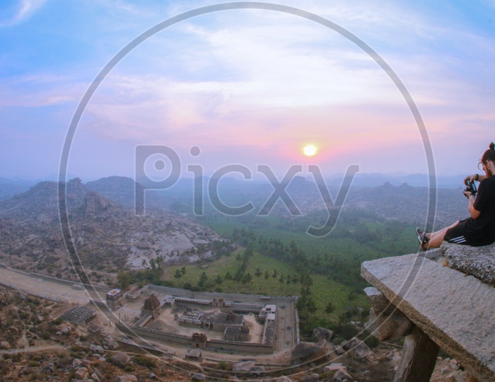 A Foreigner Enjoying The Sunset Over Rock Hills In Hampi