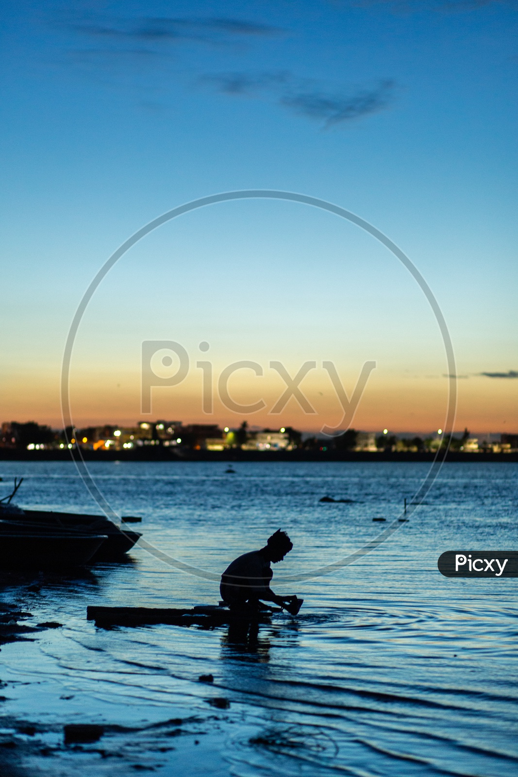 Silhouette of a Boy At The Lake  With a Blue hour Sky In Background