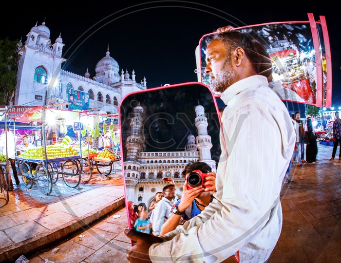A Photographer Shooting Charminar And his Reflection In A Mirror