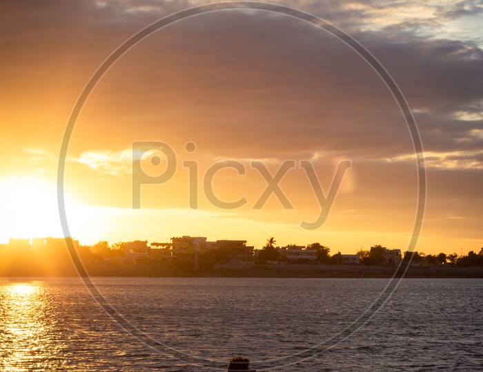 Silhouette of a Photographer  Shooting At The Bank Of a  Lake With Sunset Sky as a Background