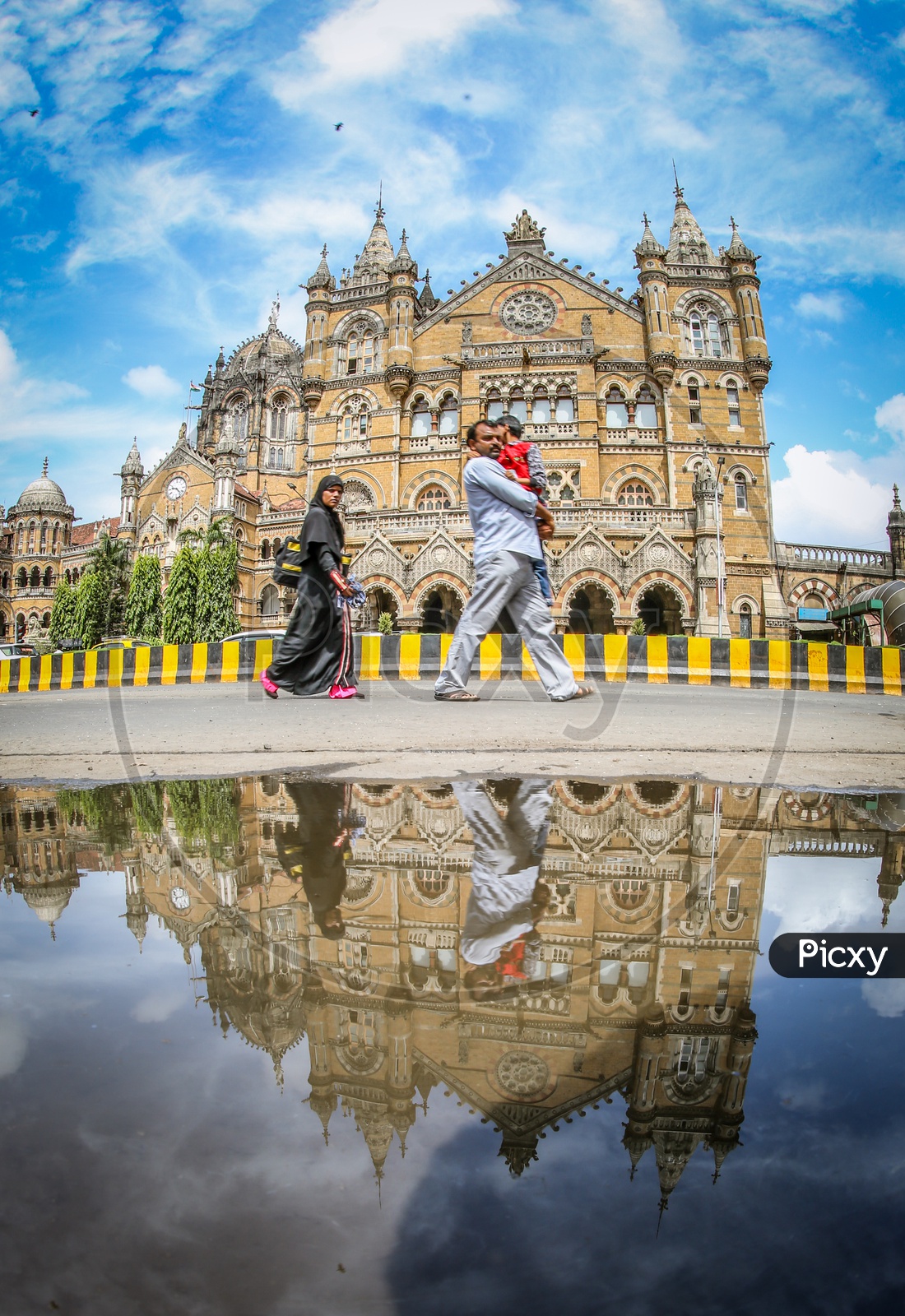 A Couple Walking On The Roads With Mumbai CST Or Chatrapati Shivaji Terminus in Background
