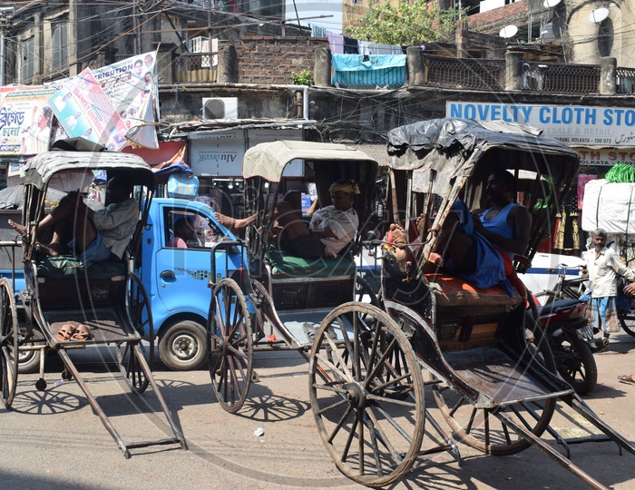 Rickshaw pullers taking a nap in a busy street
