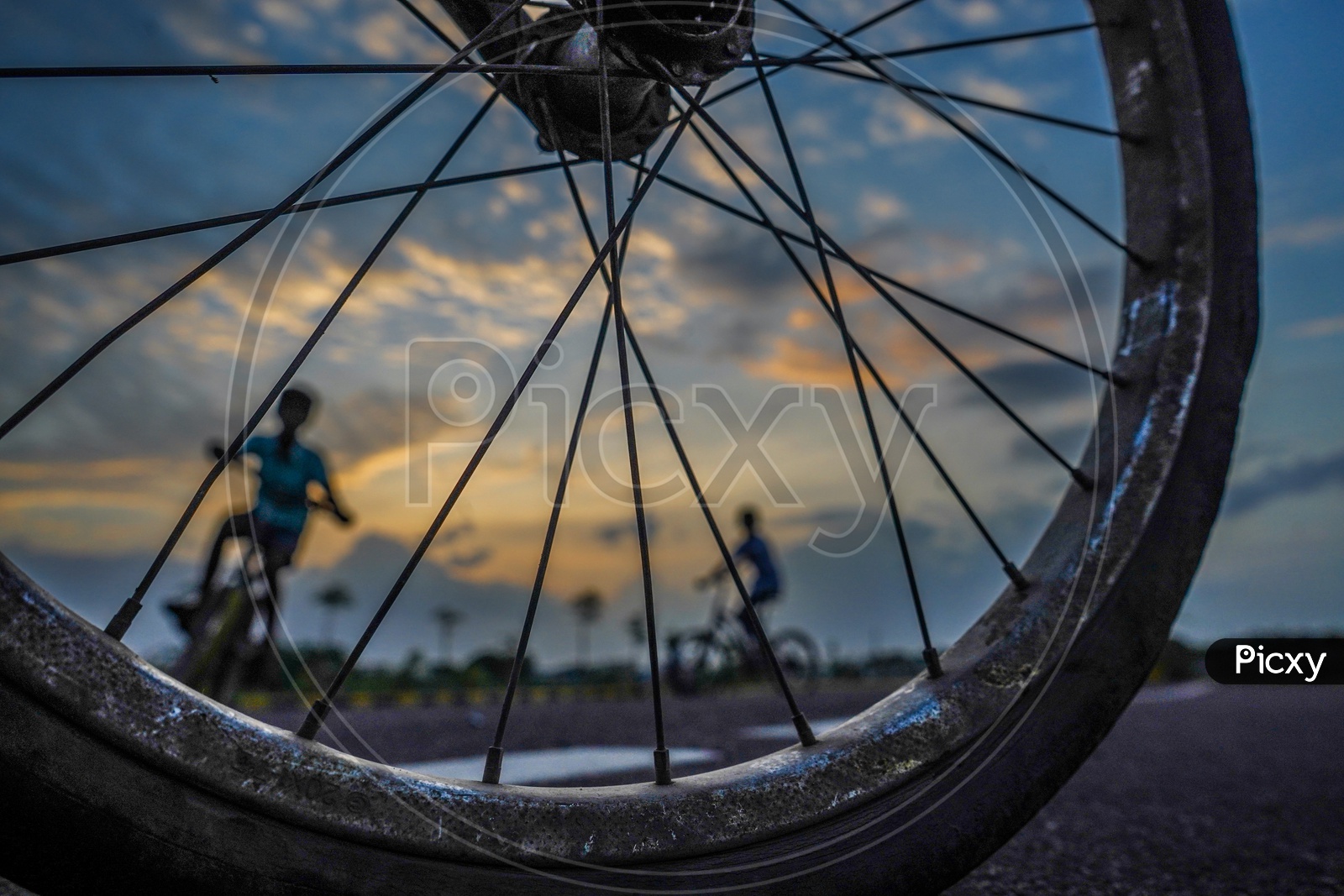 Composition Of Happy Or Joyful Indian Young Boys Performing Bicycle Stunts With Closeup of Tyre With Folks