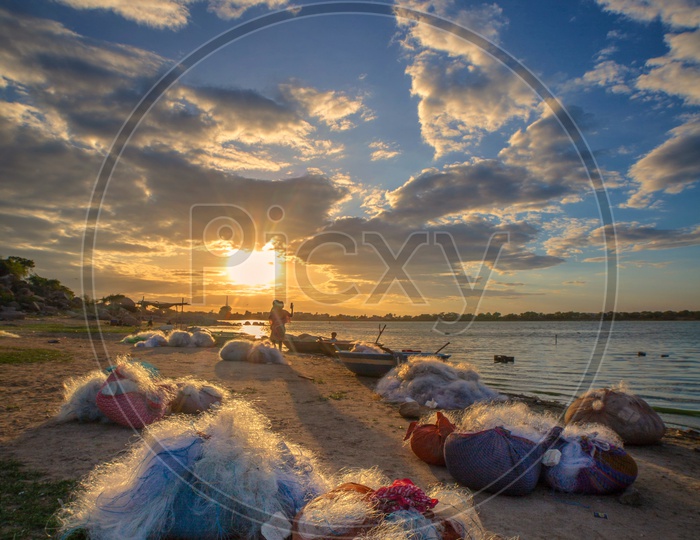 Fishing Nets On The Bank of a Lake With Sunset Sky In Background