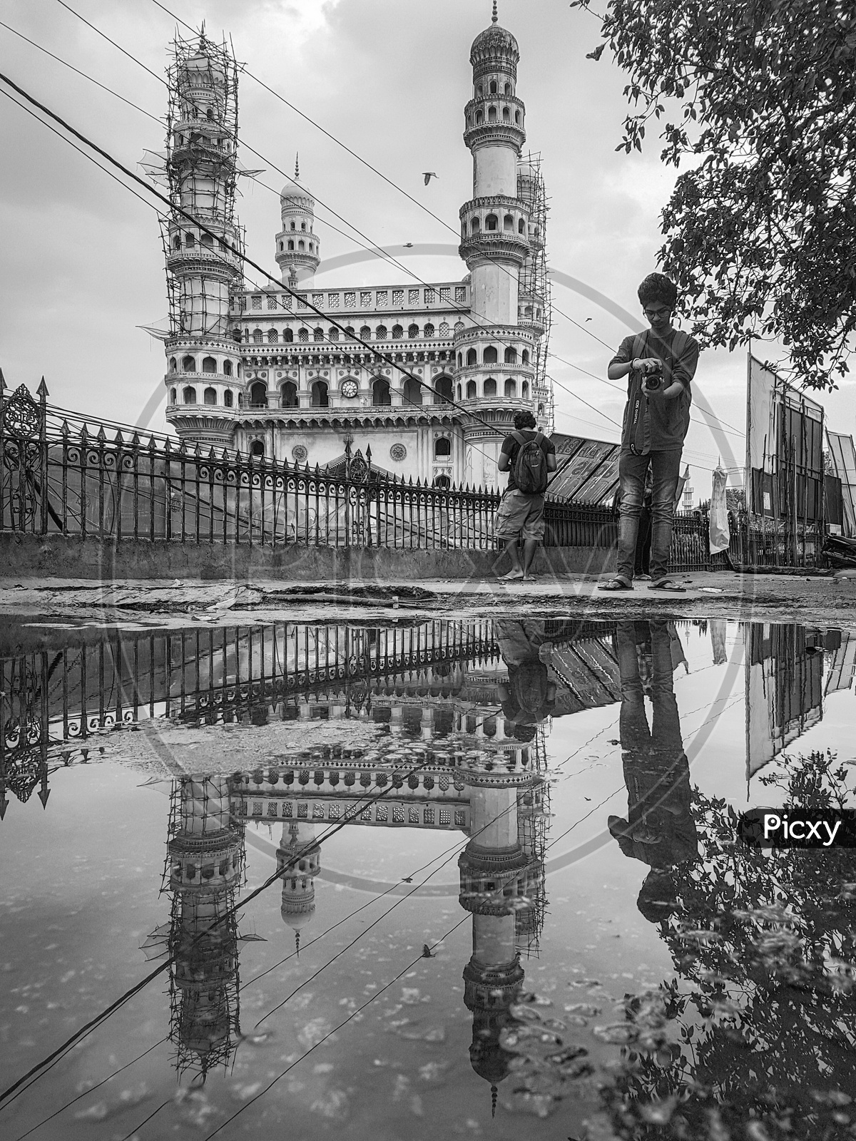 Photographers And Their Reflection on Water Surface At The Charminar