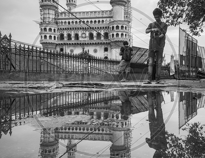 Photographers And Their Reflection on Water Surface At The Charminar