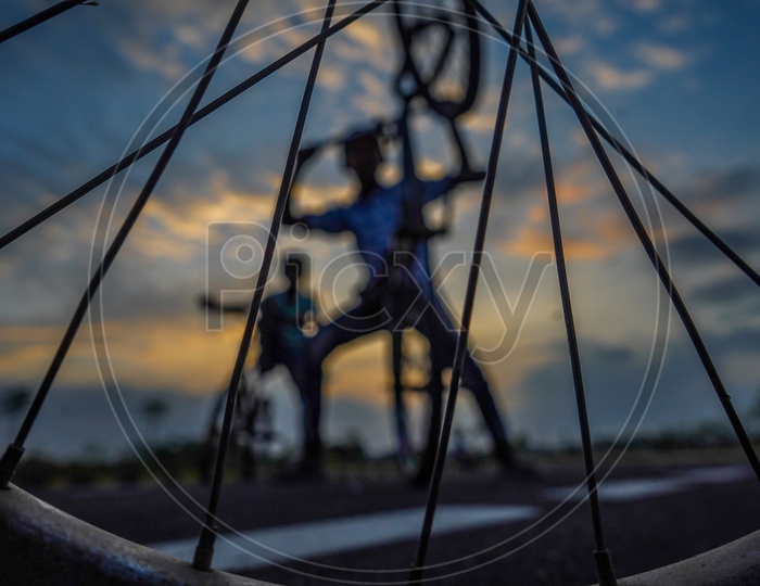 Composition Shot of Happy Or Joyful Indian Young Boys Performing Bicycle Stunts  With Closeup Of Tyre And Folks