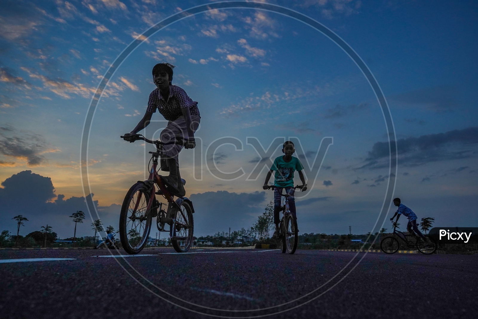 children cycling in cloudy evening