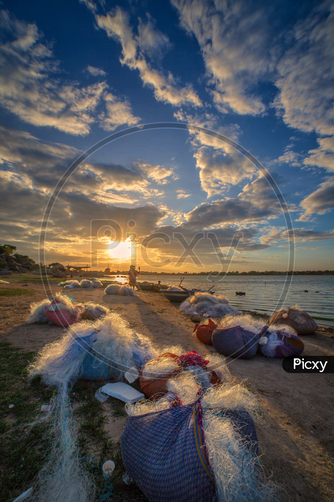 Fishing Nets On The Bank of a Lake With Sunset Sky In Background