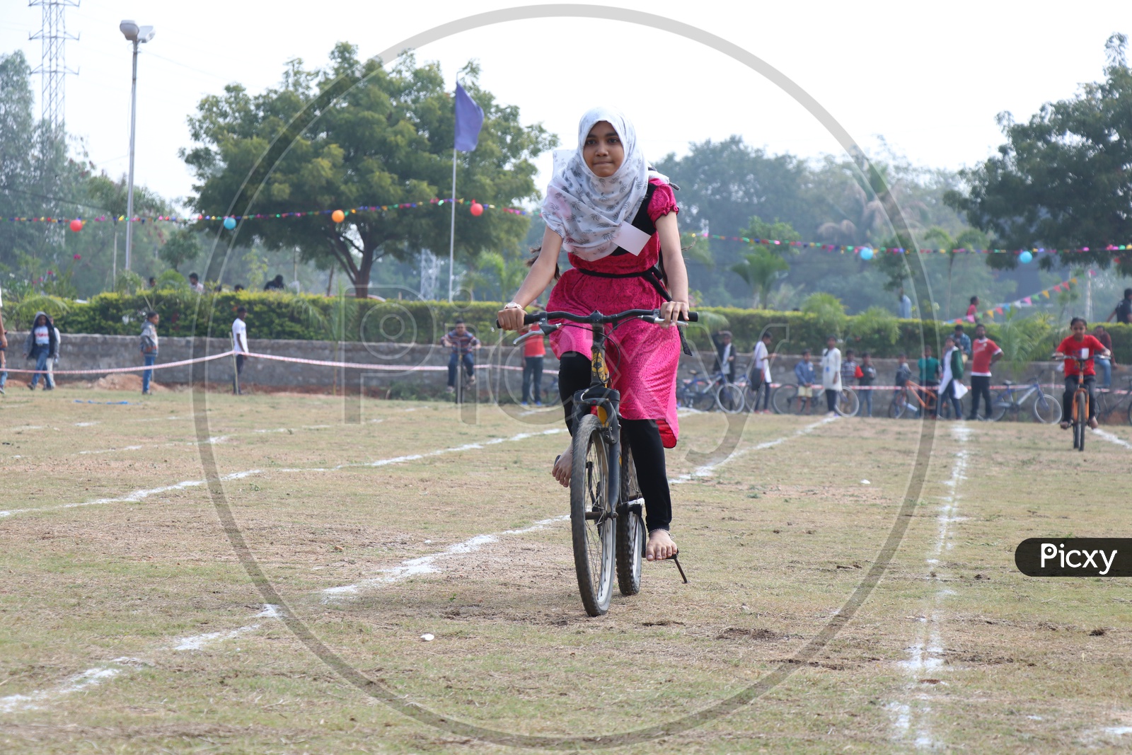 Indian Young School Girl Participating In a Cycle Race Competition In a School Sports Day Or Athletic Meet