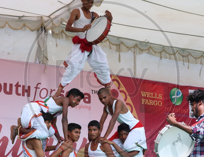 Indian Young  School Children or Students  Performing With Traditional Folk Drums On Stage In an Event