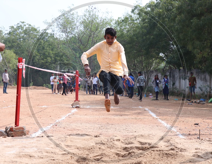 Indian Young School Boys Participating In a  Long Jump   Competition In a School Sports Day Or Athletic Meet
