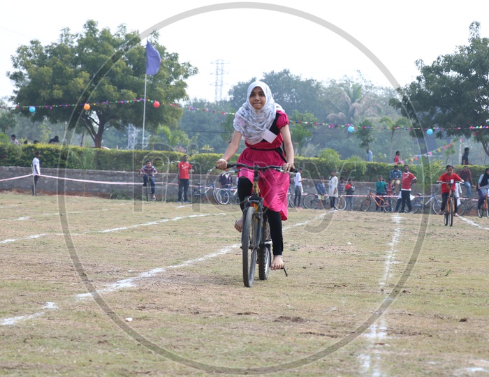 Indian You g School Girl Participating In a Cycle Race Competition In a School Sports Day Or Athletic Meet