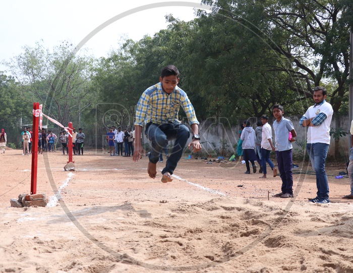 Indian Young School Boys Participating In a  Long Jump   Competition In a School Sports Day Or Athletic Meet