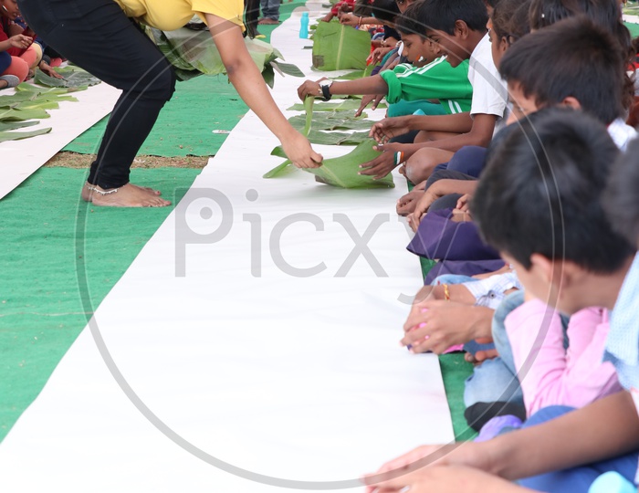 School Children Having Lunch or Enjoying Feast Outdoor Serving In Banana Leaf