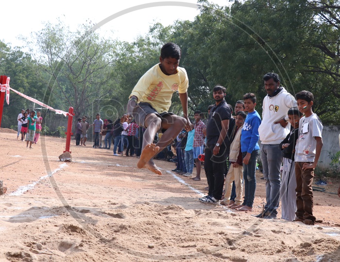 Indian School Students Or Children Participating In Long Jump Event At a School Sports Day Event or Athletic Meet