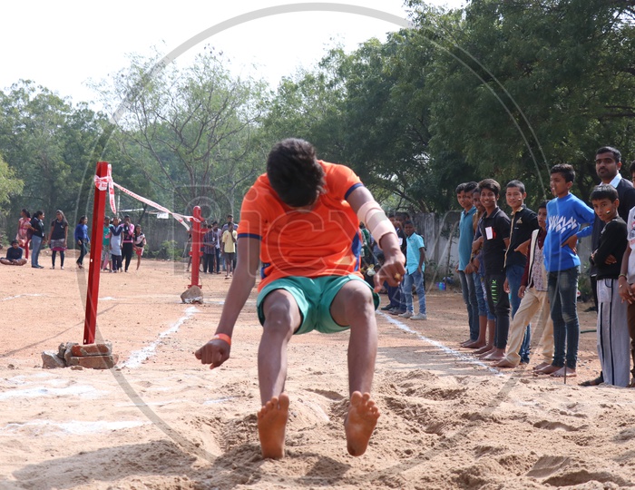 Indian School Students Or Children Participating In Long Jump Event At a School Sports Day Event or Athletic Meet