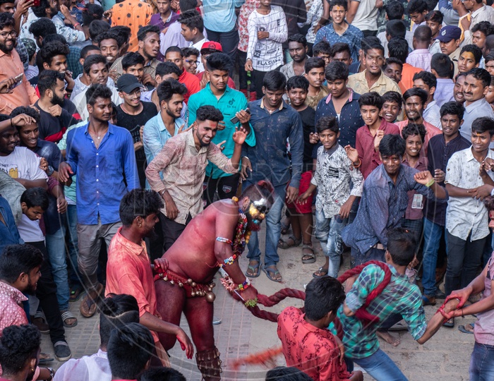 Pothuraju  Being Beating  And Dancing Along The Crowd With  Red Coloured Lashing  Whips And With Neem  Leafs  at Bonalu Festival