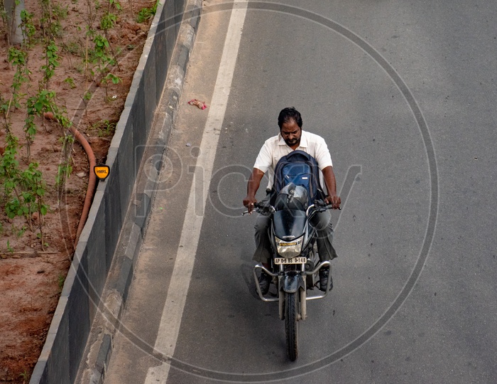 Riding a motor bike without wearing a helmet.