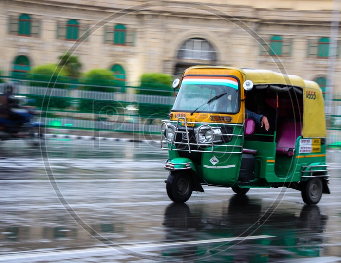 An auto rickshaw on the road after rains
