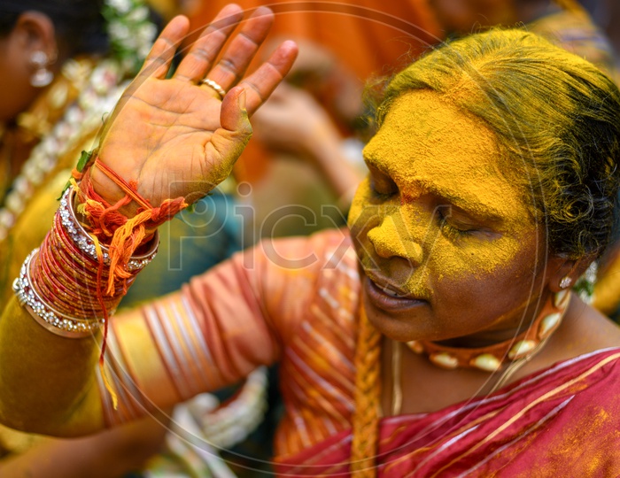 Portrait Of a Woman Applying Yellow Colour  Turmeric  To Their Foreheads At Bonalu Festival Celebrations