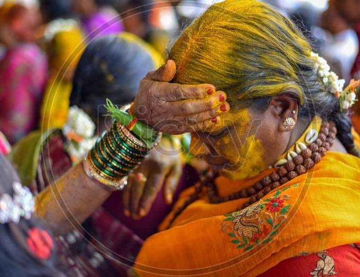 Woman Applying Yellow Colour  Turmeric  To Their Foreheads At Bonalu Festival Celebrations