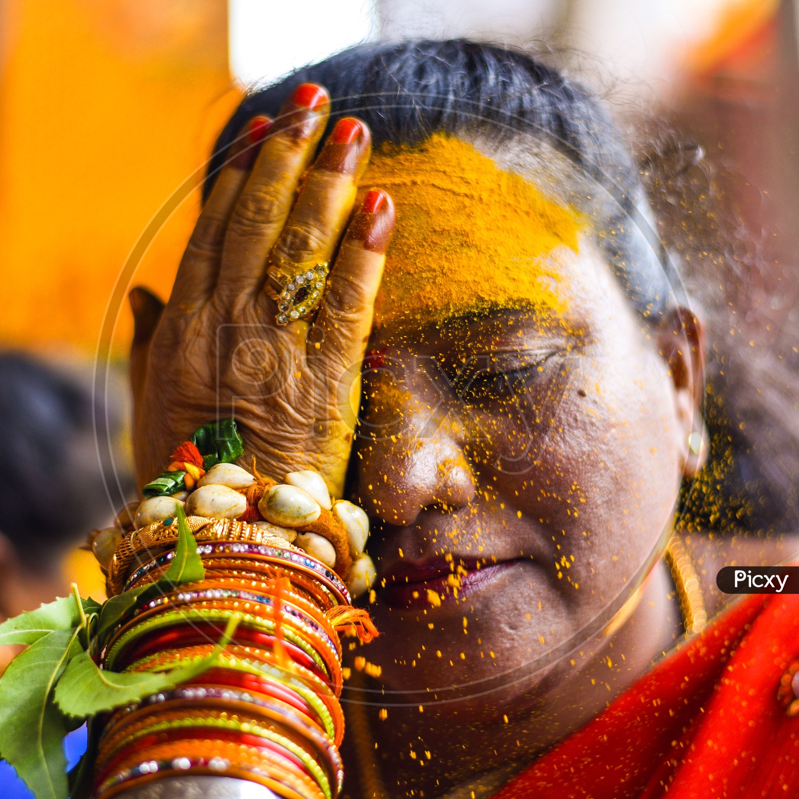 Woman Applying Yellow Turmeric To Their Foreheads At Bonalu Festival