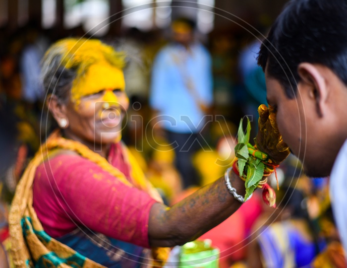 Woman Applying Yellow Turmeric To  Foreheads At Bonalu Festival