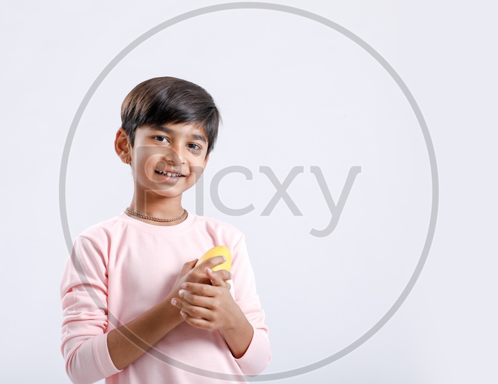 Indian Cute Boy  / Asian Boy or kid Holding Mango With an Expression On an Isolated White Background
