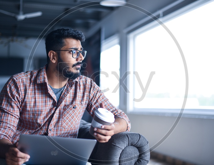 Focused Serious Working Young Man Or Indian Man On Laptop  in a Office Space