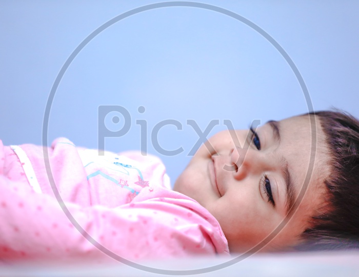 Cute Indian Baby Girl Playing On Bed