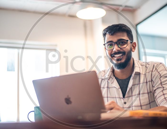 Student Indian  IT  professional Employee Young Man  Happily Smiling Using Laptop in Working Space
