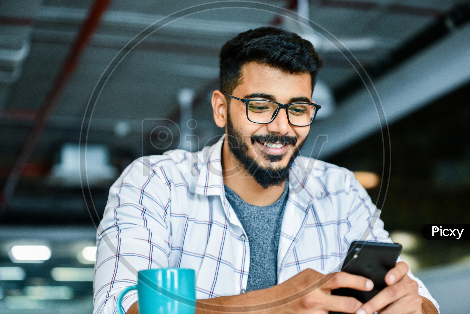Indian Young Man or Student Using Mobile or Smartphone  With Smiling Face