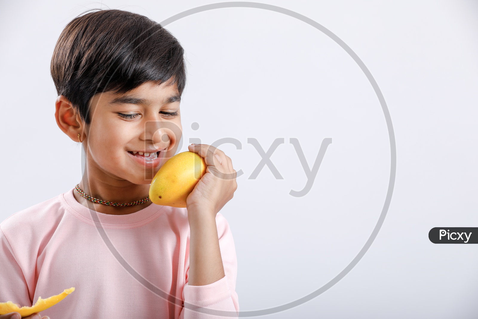 Indian Cute Boy  or  Asian Boy or kid Holding Mango With an Expression On an Isolated White Background