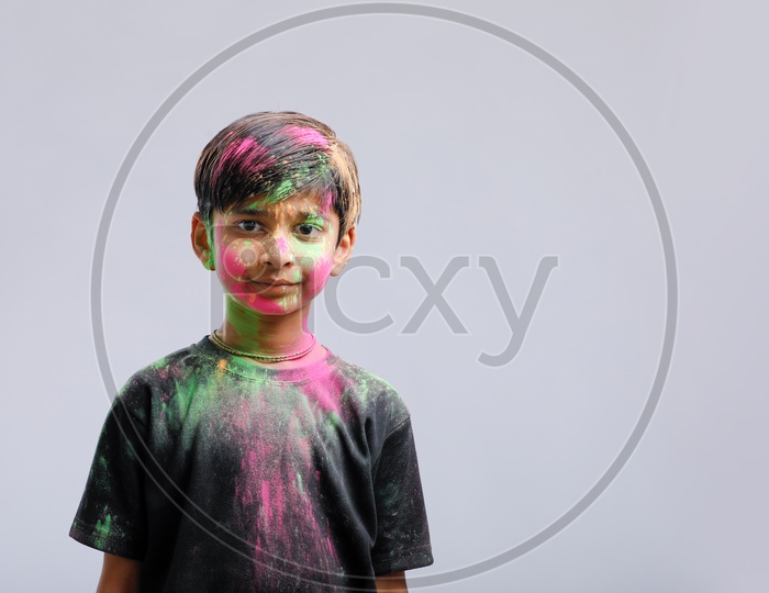Indian Boy Playing With Holi Colours and Giving Multiple Expressions Over An Isolated White Background