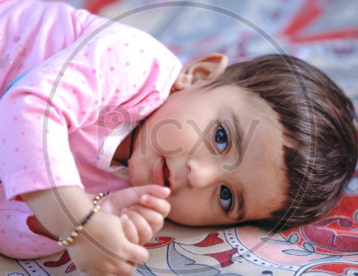 Cute Indian Baby Girl Lying On Bed