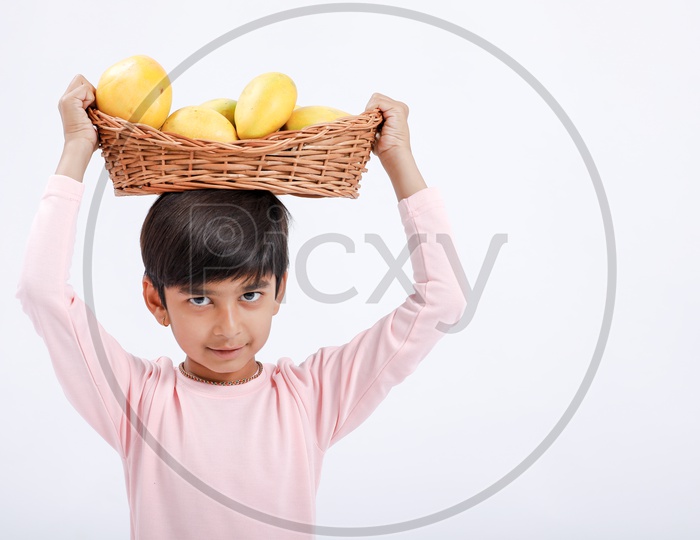 Indian Cute Boy  / Asian Boy or kid Holding Mango Basket  With an Expression On an Isolated White Background
