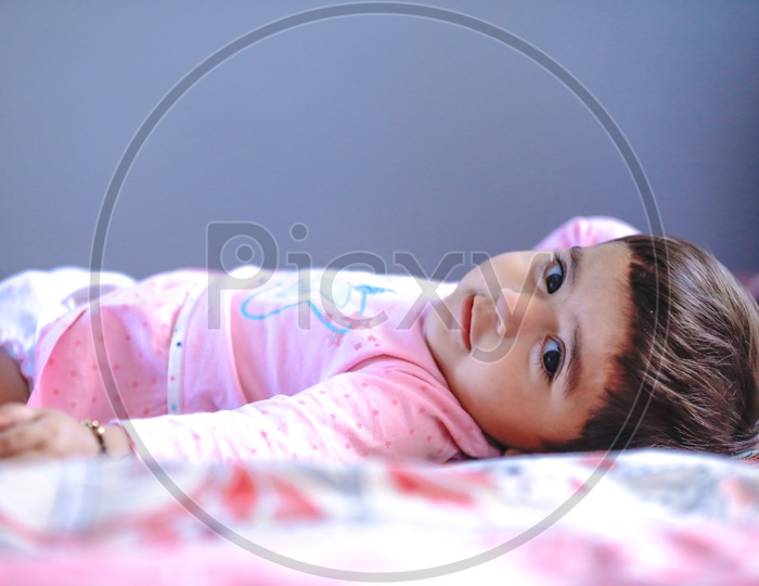Cute Indian Baby Girl Lying On Bed