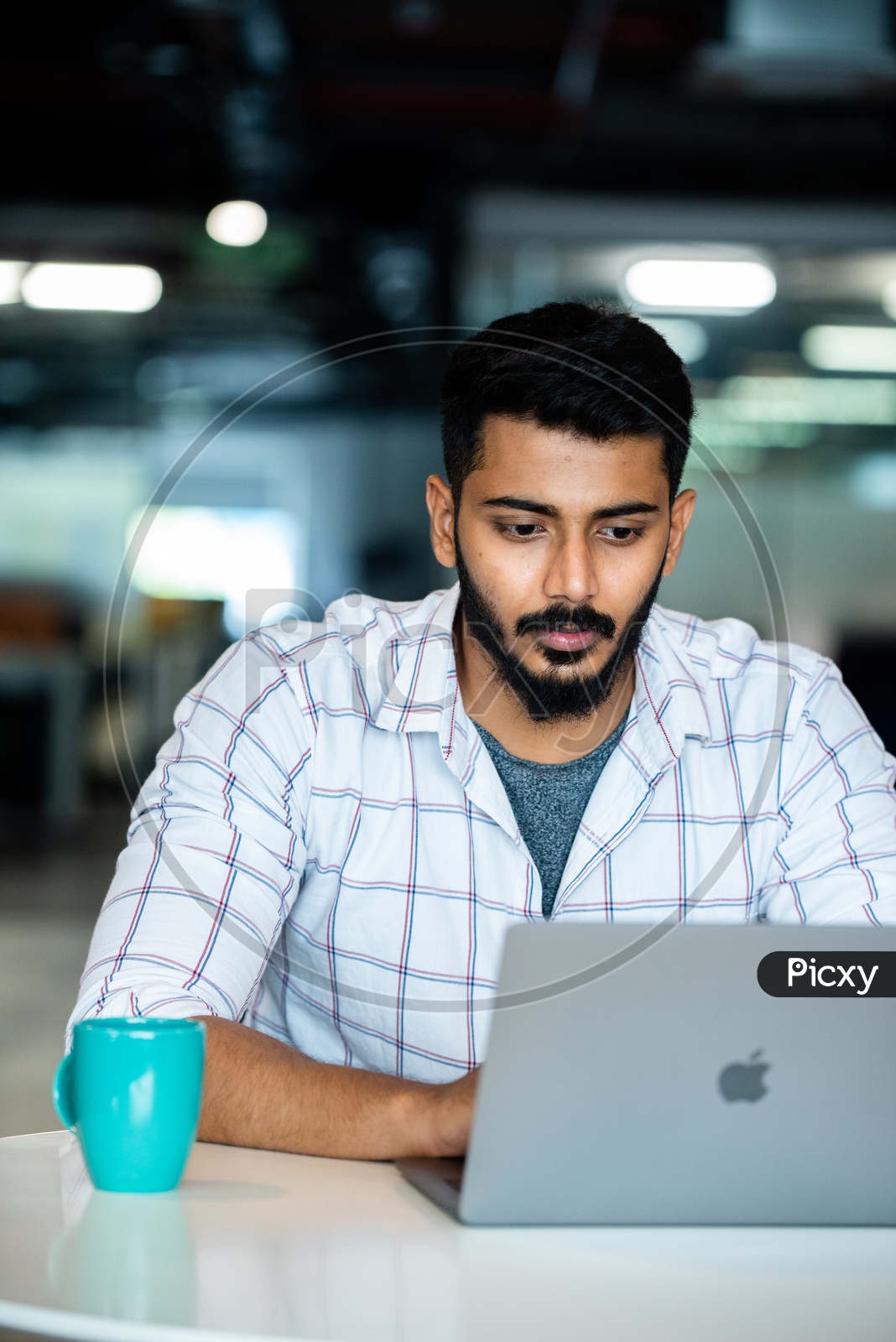 Focused Serious Working Indian Professional Employee  Young Man  On Laptop In Office Work Space