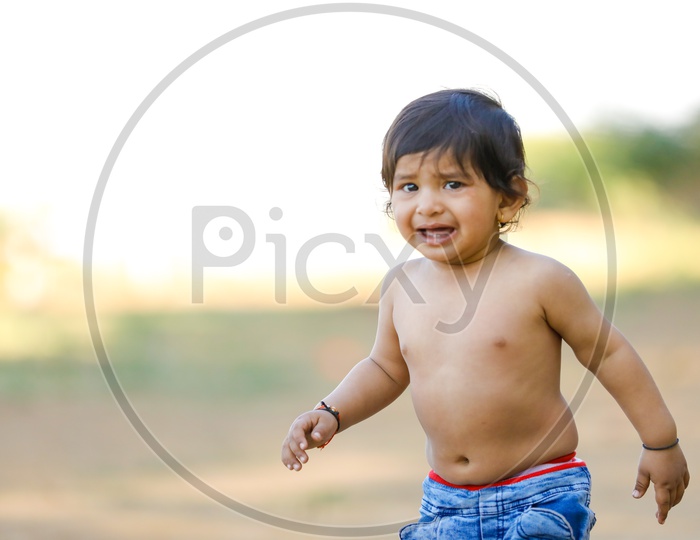 Indian Baby Girl Or Girl Child Playing In Park With A Smiling Face