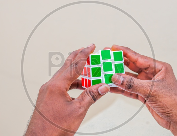 Hands and Rubik's cube puzzle isolated on the white background