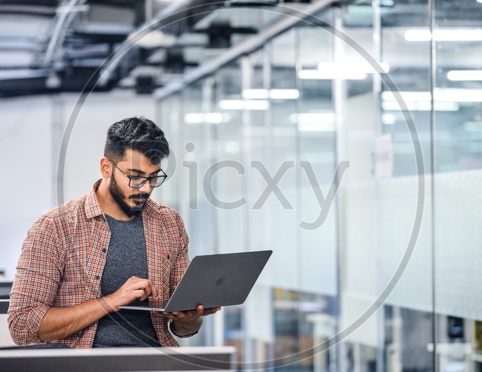 Young Man Or Indian Man  Focused Serious Working On Laptop In Office Work Space
