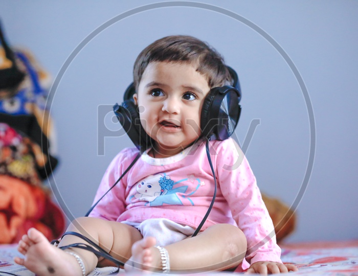 Cute Indian Baby Girl Listening Music  In Headphones