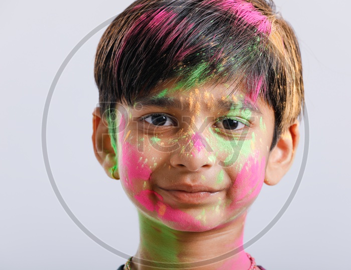 Indian or Asian Boy Playing With Holi Colours and Giving Multiple Expressions Over An Isolated White Background