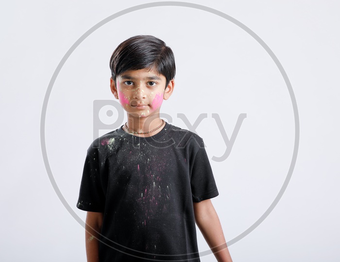 Indian Boy Playing With Holi Colours and Giving Multiple Expressions Over An Isolated White Background