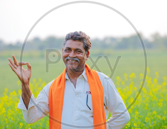 Indian Farmer In Agricultural Field With Happy Gestures Indicting The Crop