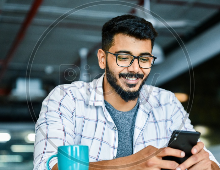 Indian Young Man or Student Using Mobile or Smartphone  With Smiling Face
