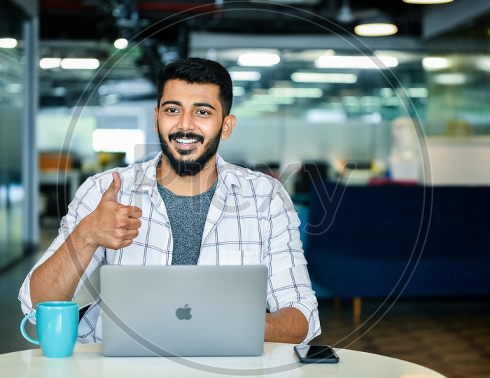 Confident Young Man or Indian Man Or Student With Thump Up Gesture Happily Smiling With Laptop on Desk