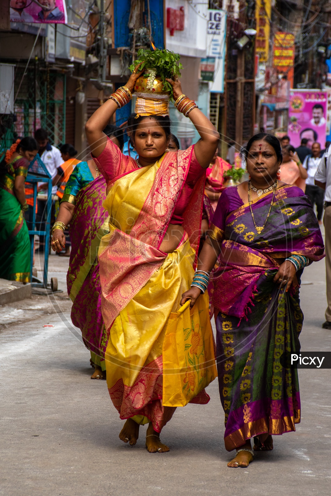 Women dressed up in traditional wear carrying bonalu to Ujjaini Mahankali Temple, Secunderabad on the eve of Bonalu festival .