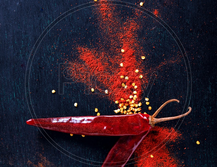Red Chilli  Or Pepper Powder  With Chilli  Flakes On an Isolated Black Background